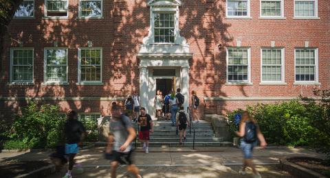 time lapse of students walking into and out of a brick academic building