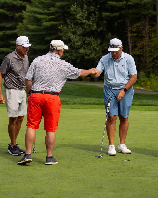 A group of men celebrating while playing golf