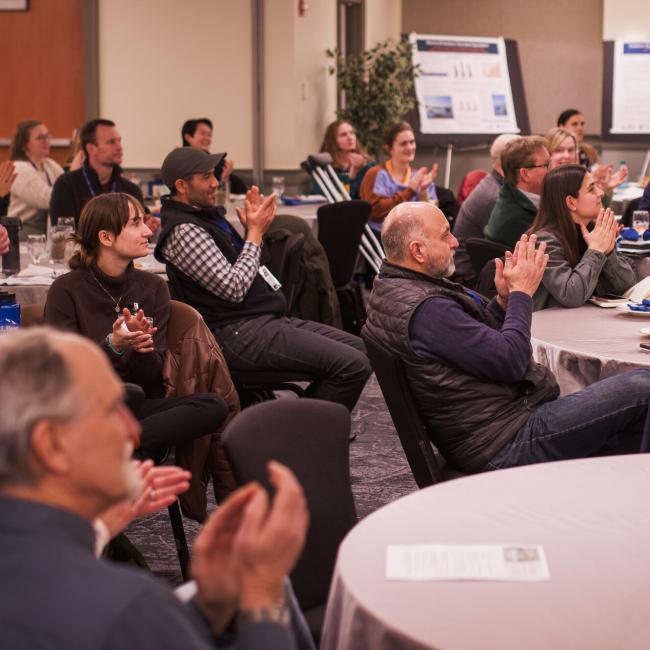 Group of people clapping during a presentation